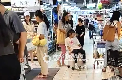 何妤玟（中）推著小女兒呱呱來到蔬果區，大女兒恬恬在旁看冷藏食品。特勤中心攝