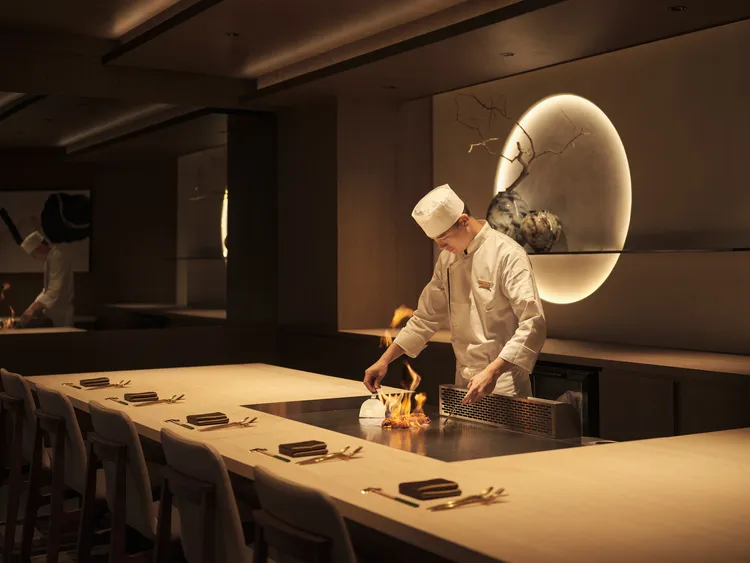 店內空間設計以日式木質調性打造靜謐雅致空間，可近距離欣賞主廚料理秀。業者提供