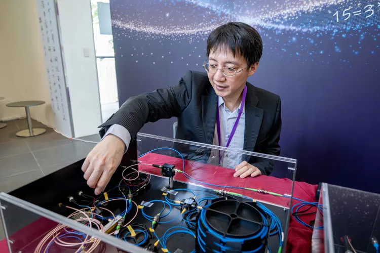 褚志崧展示以在一條環狀光纖內跑動、只有一顆光子的光量子電腦來完成質因數分解運算。清華大學提供