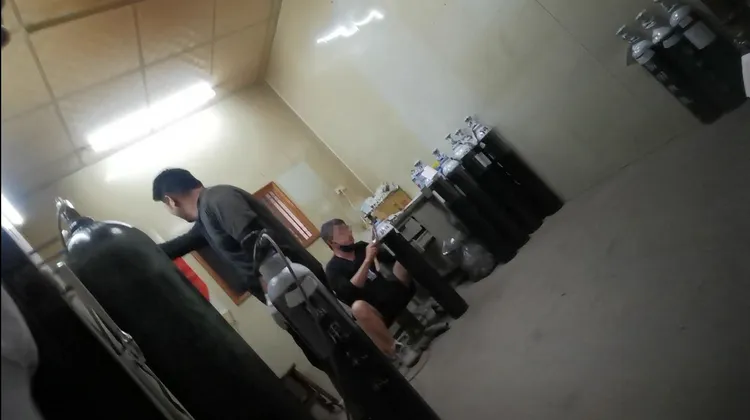 昞暉氣體公司陳姓業者（坐）正在為醫用氧氣鋼瓶換貼偽標。爆料人提供