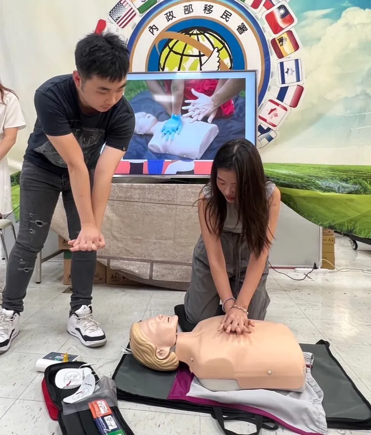 張庭維（左）指導新二代大使如何進行心肺急救。移民署提供