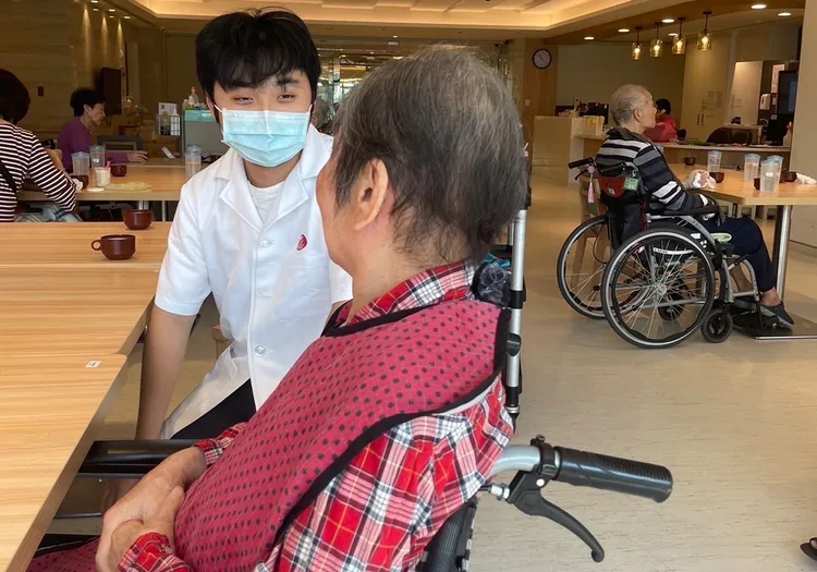 張庭維（左）平日用愛心照顧老人，期許自己能以男丁格爾回饋社會。移民署提供