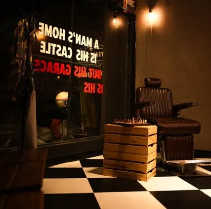 「避難所理髮廳」店內氛圍沉浸，西洋棋盤格地板搭配復刻皮座椅。業者提供