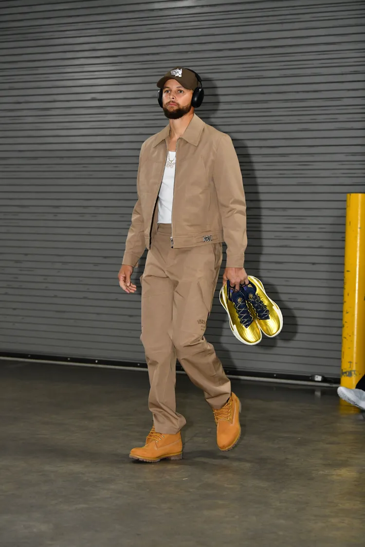 Curry搭配Versace棉質帆布外套、帆布長褲，並拎上搶眼的UNDER ARMOUR金色戰靴。品牌提供