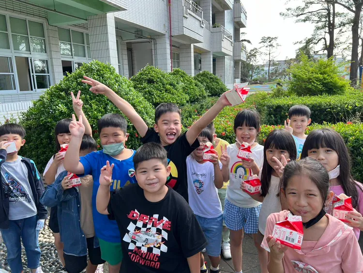 仁武八卦國小學童開心飲用鮮乳。農業局提供