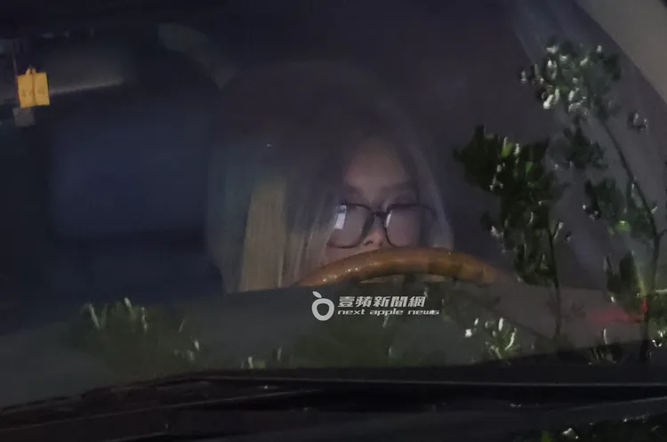 李愛綺戴老花眼鏡在車上滑手機。特勤中心攝