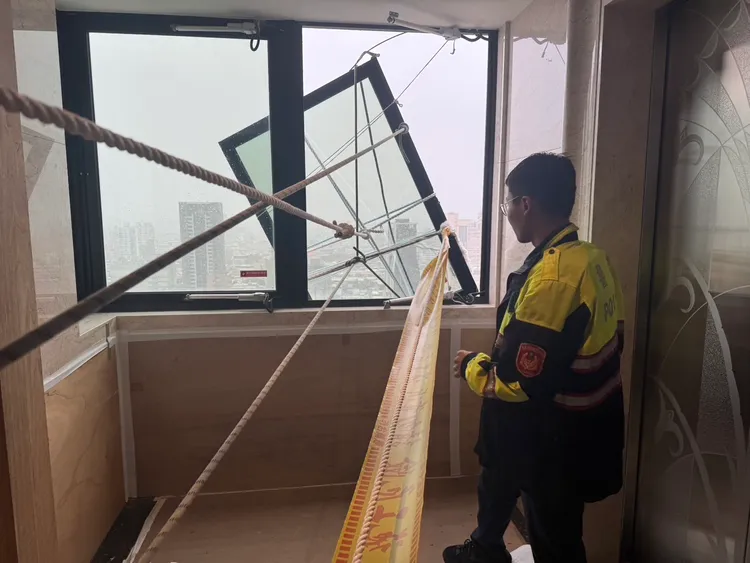 三重23樓住戶窗戶搖搖欲墜，警方協同用繩索緊急固定。翻攝畫面
