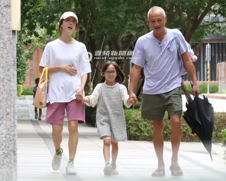 宋米秦摸著肚子跟老公一起緊牽女兒。特勤中心攝