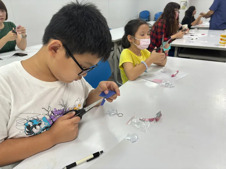 合唱團親子專注手做客家藍衫吊飾。市府提供