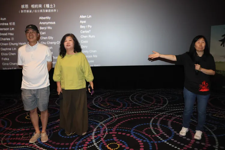 一一文創負責人張慧如(中)將鮮花轉《種土》。凃建豐攝