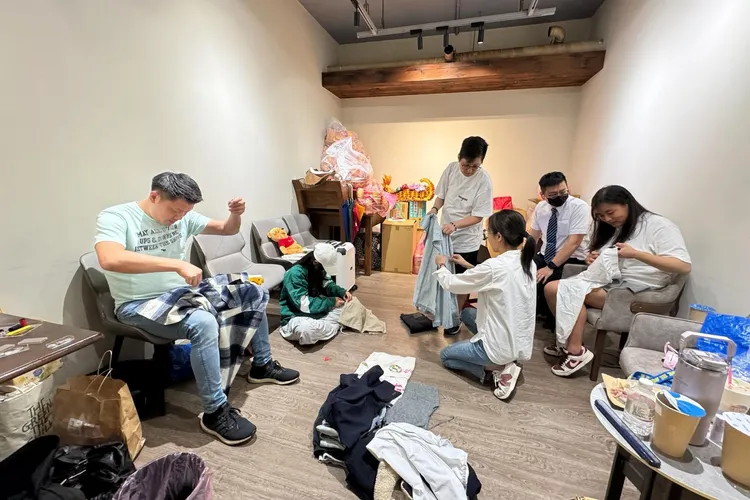 議會同仁照習俗在許家蓓的衣物口袋裝進銀紙、用針線虛縫，盼她能一路好走
。翻攝《@wangminsheng》Threads