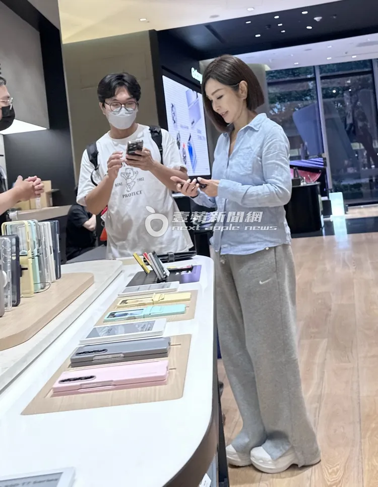 陳美鳳走到展示機旁，拿起手機仔細觀察一番。特勤中心攝