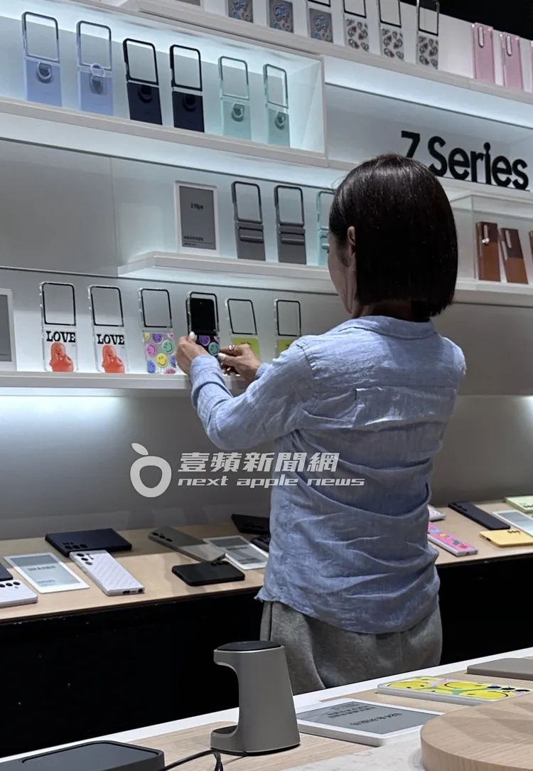 陳美鳳從口袋拿出手機，往商品架上的手機殼比劃，充滿少女感。特勤中心攝