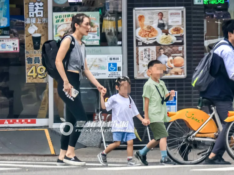 一家三口手牽手準備過馬路，畫面十分溫馨。特勤中心攝