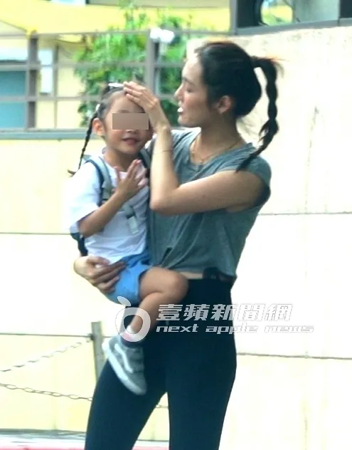 接到剛下課的女兒，王棠云抱起女兒用手幫忙整理頭髮。特勤中心攝