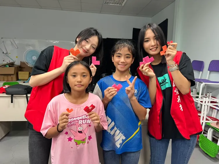 SWAG公益大使手捧孩子們親手摺的愛心紙，收穫滿滿的愛。SWAG提供