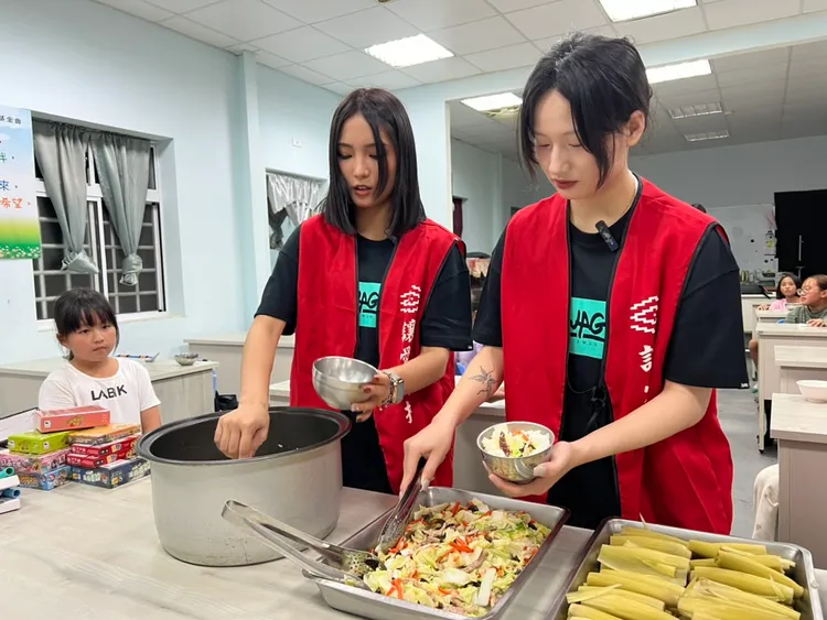 SWAG公益大使小米（左）、真真（右）協助孩童分餐。SWAG提供