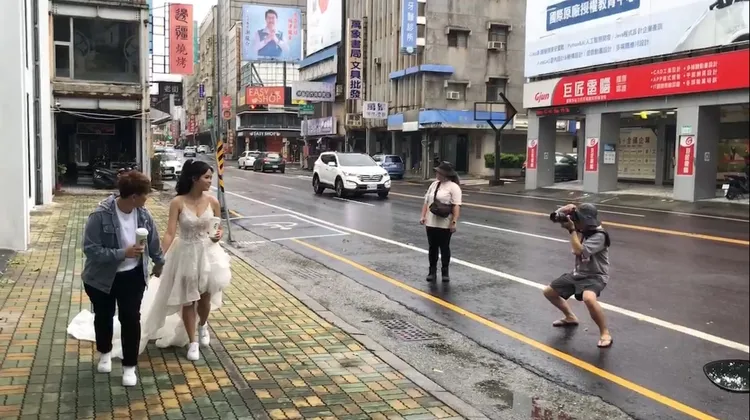 颱風天在外拍婚紗照引人側目，來自馬國的新人說是難得體驗。民眾提供