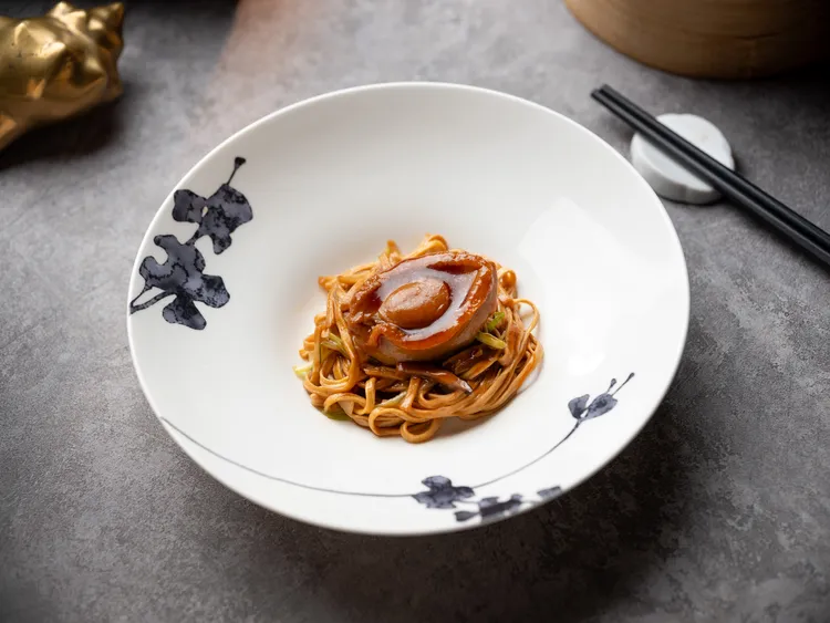 「六頭鮑魚五彩燜伊麵」主廚先將老母雞與豬肉炸出香氣後，加上高湯與鮑魚煲煮四小時而成的精華湯汁，並與伊麵及五彩鮮蔬一同燉煮，並於上鑲上整顆的六頭鮑魚，每一口都能品嘗到鮑魚的鮮甜。業者提供