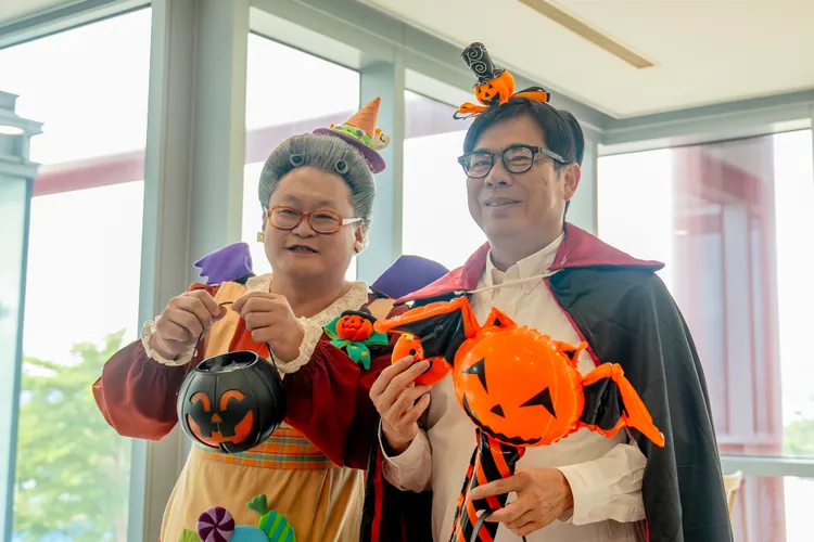 水果奶奶（左）和高雄市長陳其邁為萬聖節打扮，特別準備糖果。高雄市政府提供