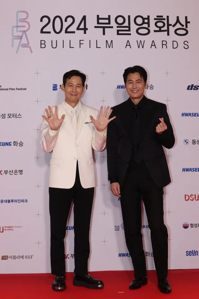 「清潭洞夫妻」李政宰（左）、鄭雨盛一黑一白攜手走紅毯。翻攝釜日電影獎