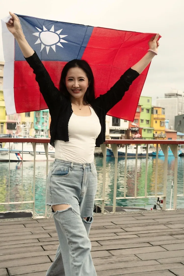 謝忻跑去基隆最美的彩色街屋拿著國旗拍照。翻攝謝忻臉書
