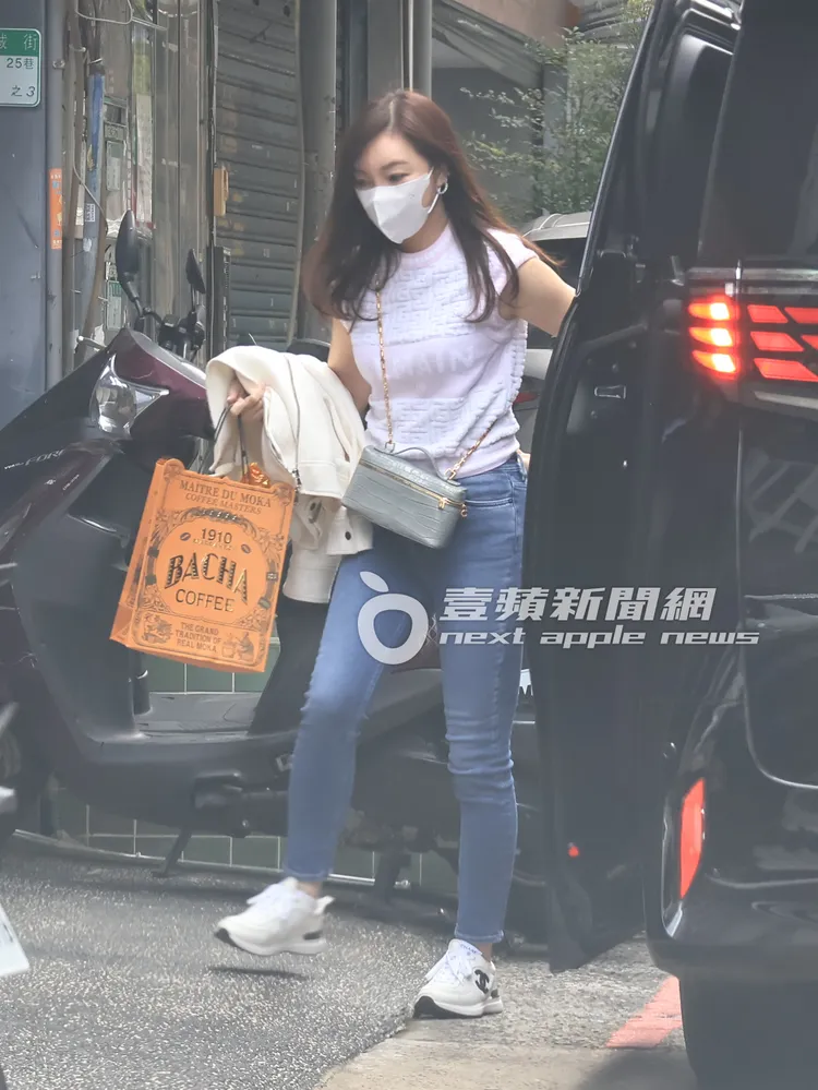 曾馨瑩身穿BALMAIN上衣、腳踩香奈兒鞋，提著1袋酒赴約。特勤中心攝