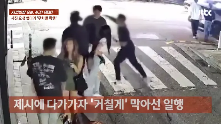 一名男子（右）突然對18歲男粉絲出拳。翻攝JTBC