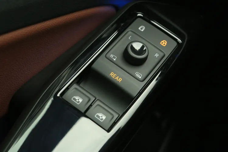 駕駛座旁的電動窗開關，也整合了觸控式機能，只要按下REAR就能控制後座兩扇側窗，進一步減少實體開關、視覺更清爽。林浩昇攝