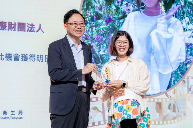 張善政頒發聖保祿醫院王韻婷優良專業長照人員獎座。桃園市府提供