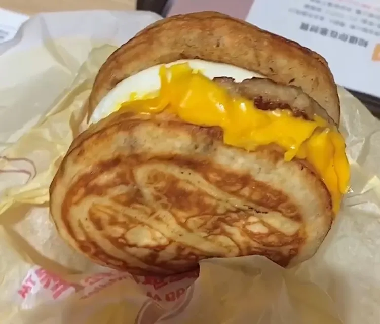 麥當勞鬆餅漢堡吸引民眾排隊搶購，連詐騙車手出發前也來買一個解嘴饞。翻攝畫面