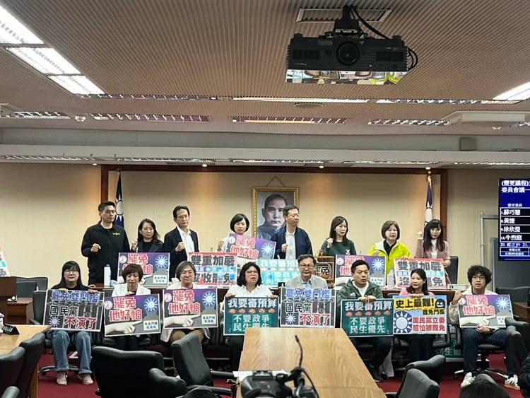 民進黨立委們手持「我要審預算，不要政爭、民主優先」、「罷免雙門檻，國民黨不演了」的標語，嚴正守住主席台。記者葉家瑋攝