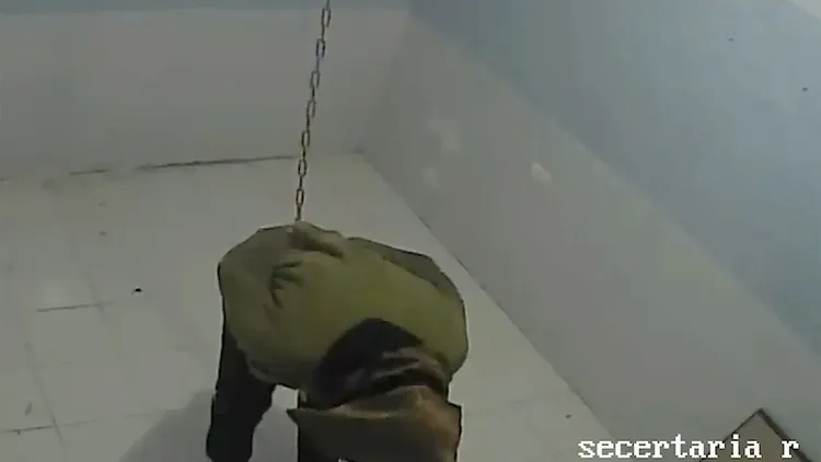 一位加薩平民雙手綁著被吊起。翻攝自《紐約郵報》