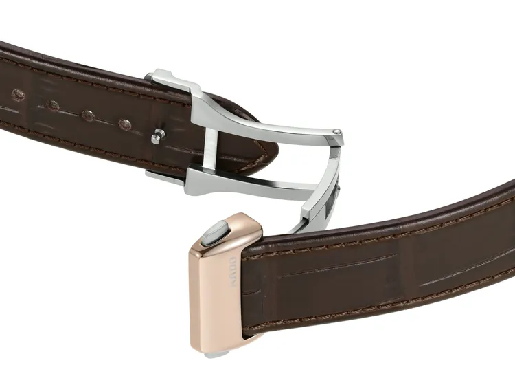 腕錶以棕色皮革錶帶搭配鈦金屬伸縮折疊錶扣。品牌提供