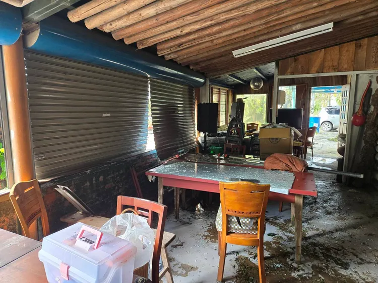 加蜜園餐廳鐵門被強風吹壞窗戶玻璃碎裂散落屋內。李光濱攝