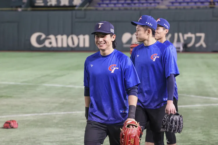 世界12強棒球賽複賽台灣隊22日在東京巨蛋與美國隊交手，台灣隊長陳傑憲（前）賽前與隊友一同在場上練習。中央社