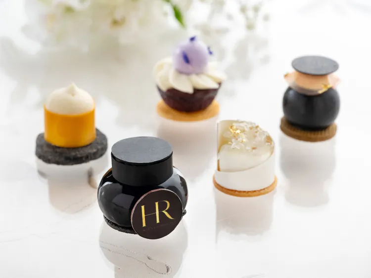 由台北文華東方酒店行政西點主廚趙崇曦發揮巧思，以赫蓮娜品牌標誌奢華金色與黑白繃帶乳霜的黑、白色系營造華麗靈感，結合鮮果與健康食材，精彩演繹一系列滿盈著雅緻光彩及美麗潤澤的誘人美點。業者提供