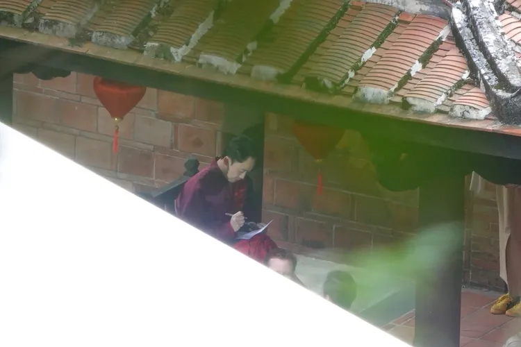 薄瓜瓜換上深紅色中式唐裝，坐在板凳上確認流程。特勤中心攝