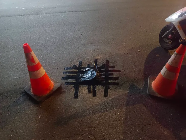 警員以黑色膠布將人孔蓋黏貼固定。蘆竹警分局提供