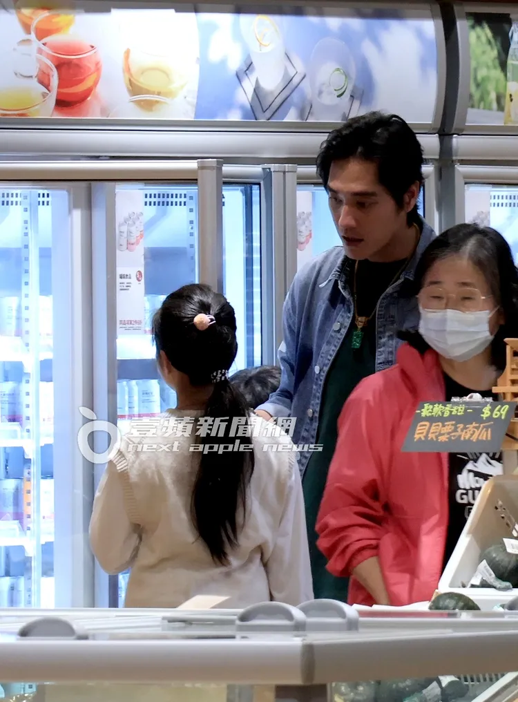 姊弟倆在飲料櫃前躊躇許久買了蘋果汁，藍正龍拿了包小零食帶兒子去排隊結帳。特勤中心攝