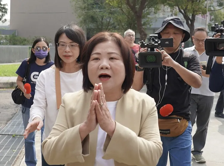 勞動部前部長許銘春21日出面受訪，鄭素玲(白衣者)緊跟在後。中央社