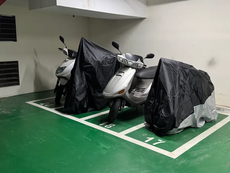 記者直擊多部重機直接蓋上防塵罩長期占位，讓運動民眾無法停車。攝影中心