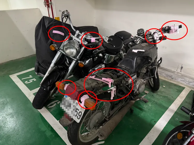 不少破舊重機占用車位，即使貼滿勸導單也不移車，已變成樂廢棄車堆置場。讀者提供