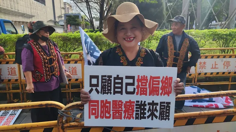 偏鄉民眾手持標語槓上本土小牙醫，希望有人願意到偏鄉提供醫療。范武吉提供