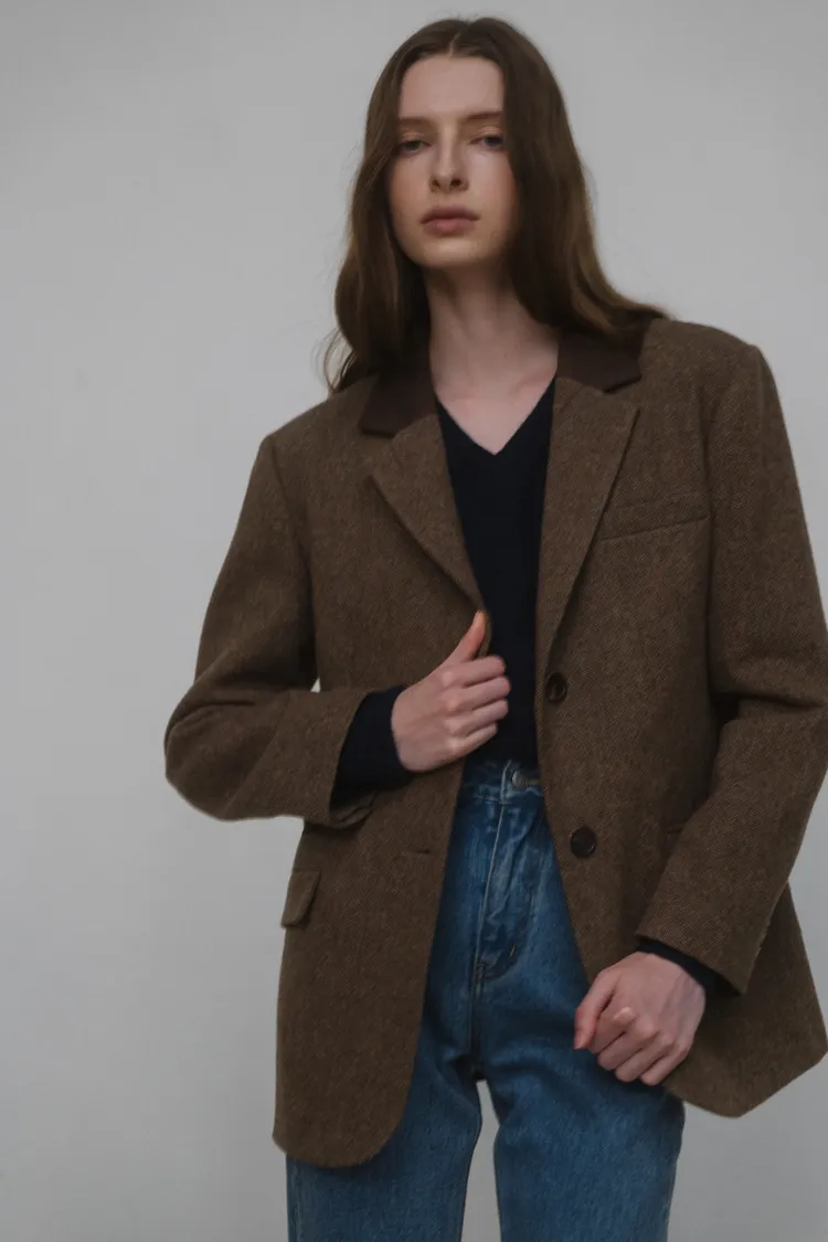 西裝外套在半寬鬆廓形中搭配簡單有力的劍領與墊肩。品牌提供