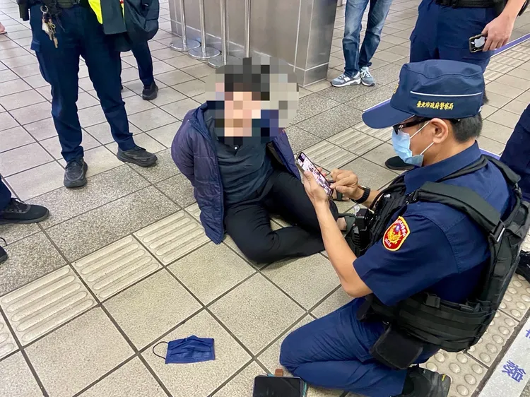 身穿藍色外套的王女被警方上銬，壓制在地面上動彈不得。翻攝畫面