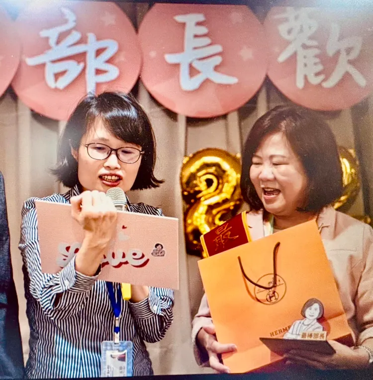 名嘴黃益中拋出照片證明，送許銘春愛馬仕絲巾的人不是謝宜容，而是勞動部秘書處處長丁玉珍，她手拿珍珠板上面寫著募資的同仁名單，還說「誰送的比我好」。翻攝黃益中臉書