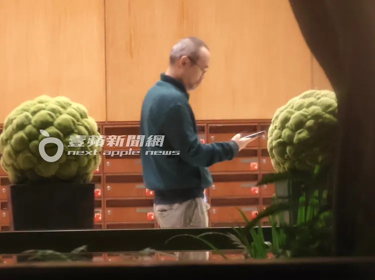 黃立成返家後低頭滑手機。特勤中心攝