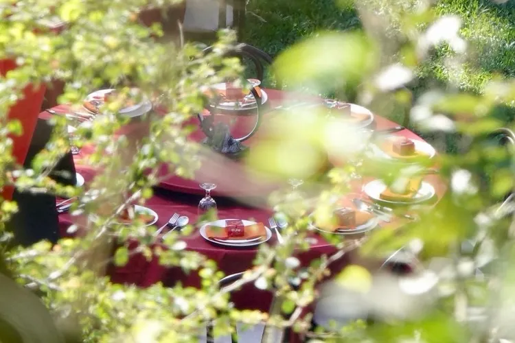 婚禮現場擺放好幾張圓桌，且餐盤上放著用紅色盒子包裝的精美小禮。特勤中心攝