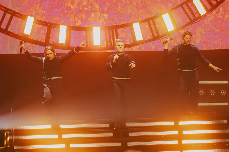 馬克歐文（左起）、蓋瑞巴洛、霍華唐納唱到一半，直接把藍白拖、茄芷袋等血拼戰利品搬上台。Live Nation Taiwan提供